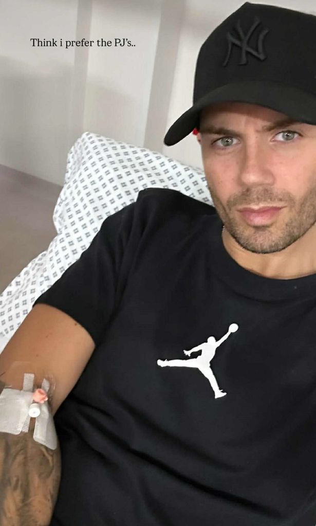 Max George in a black top and cap