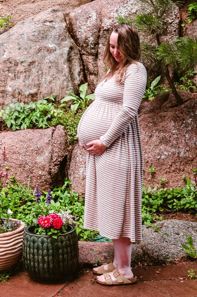 Photographer Emily, 38, shared a photo of herself cradling her bump while wearing a white and tan striped midi dress when she announced her pregnancy in June
