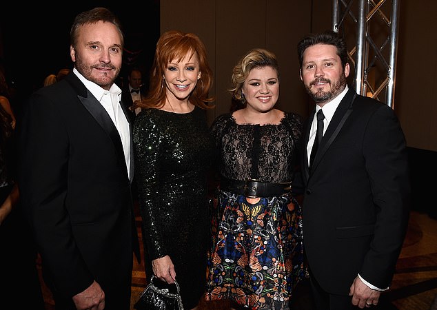 Brandon — the ex-husband of Kelly Clarkson, with whom he shared two young children — died of melanoma cancer at the age of 48 on August 7; pictured from left to right in March 2015: Brandon's father Narvel Blackstock, Reba McEntire, Kelly Clarkson and Brandon Blackstock