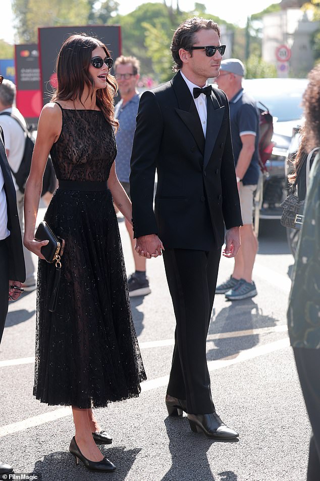 The model went braless in a revealing sheer black lace dress as she stepped out hand-in-hand with the actor to attend the premiere of The Testament Of Ann Lee