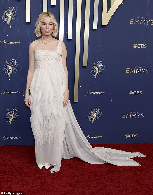 Michelle Williams, 45, appeared on the red carpet in a one-shouldered white dress with sheaths of fabric running in various directions that swamped her body and left an unflattering silhouette