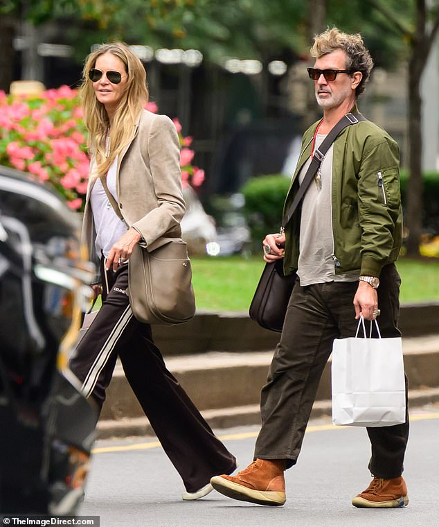 Elle looked stylish for the shopping outing in black track pants, a white T-shirt and beige blazer