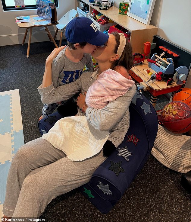 And lastly, Kloss spent quality time with one of her sons as she gave him a kiss while inside what appeared to be a small classroom