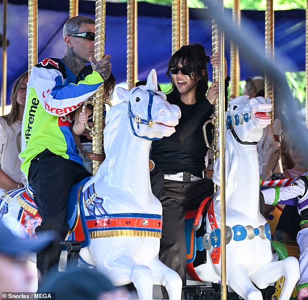 Kourtney Kardashian beamed with delight while riding the King Arthur Carrousel alongside her neighbor-turned-husband Travis Barker and their son Rocky Thirteen at Disneyland Park in Anaheim, CA on Monday