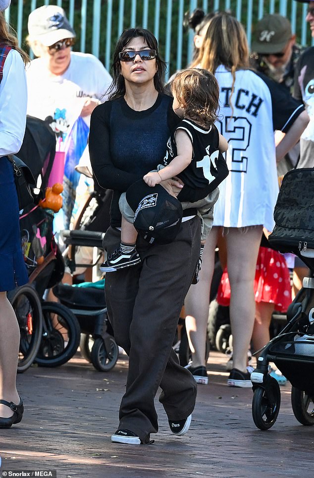 The 46-year-old reality star blended into the crowd wearing a black long-sleeve top, baggy brown trousers, and black 'Dues Paid' sneakers from the 49-year-old drummer's upcoming collaboration with Vans