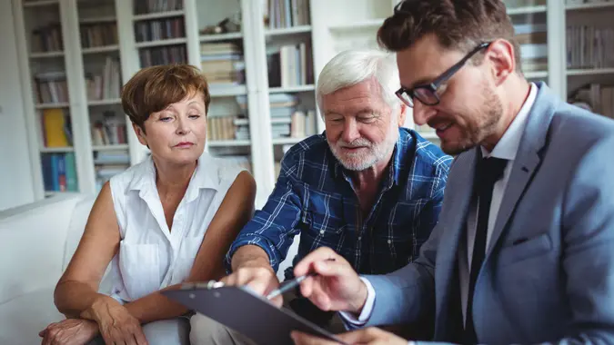 Senior couple speaking with a financial advisor about finances, retirement, investments and more.