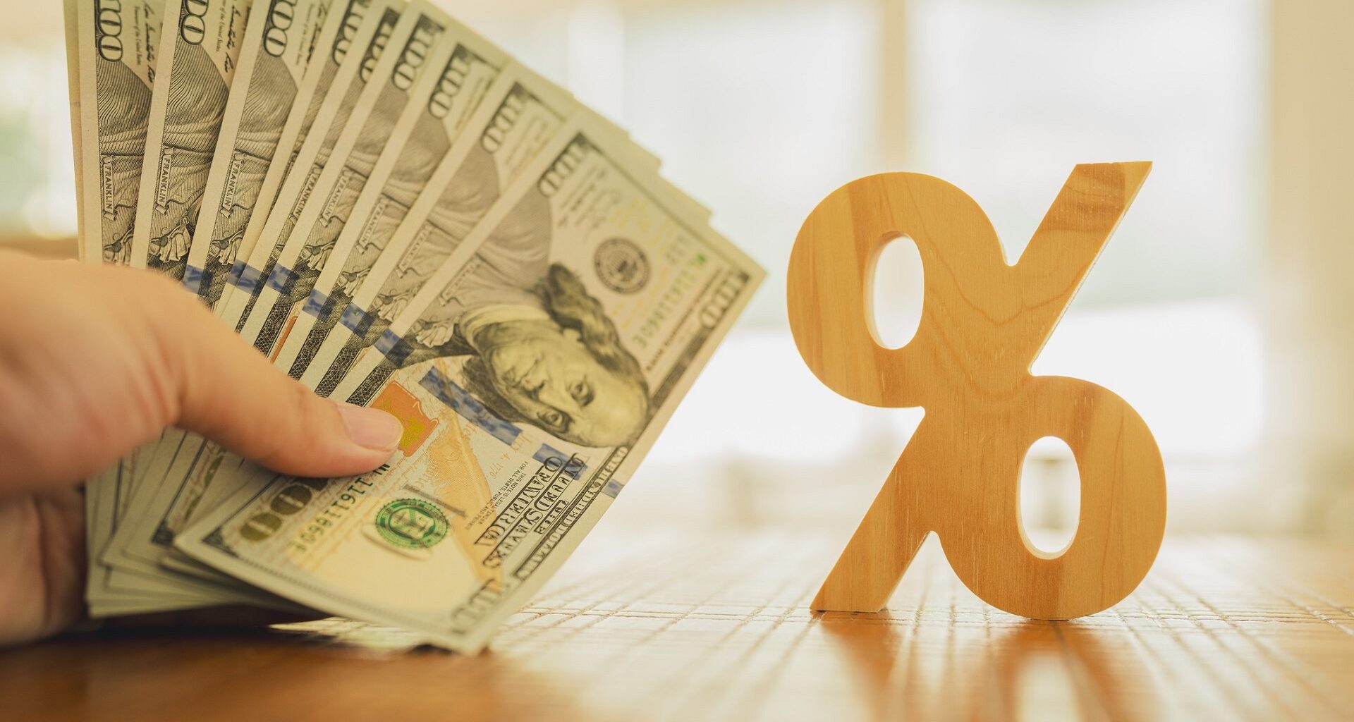 Percent symbol with people holding money that is many dollar bills. Concepts of the banking system, rising interest rates, inflation, deflation, and savings. stock photo