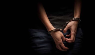 A teenager hands in handcuffs