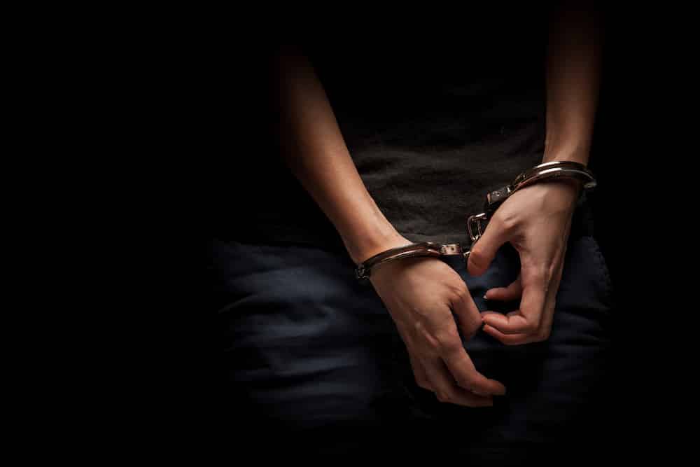 A teenager hands in handcuffs