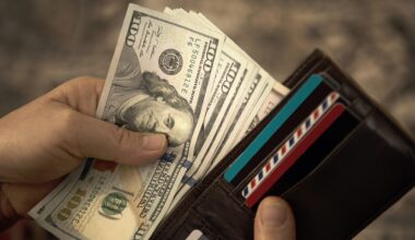High angle view of unrecognizable mature man placing USA Dollar bills into wallet stock photo