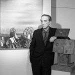 A man with an arm leaned against a sculpture of a man.