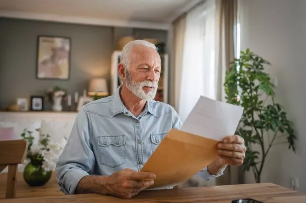 Senior man open and read a letter document from envelope whit good news