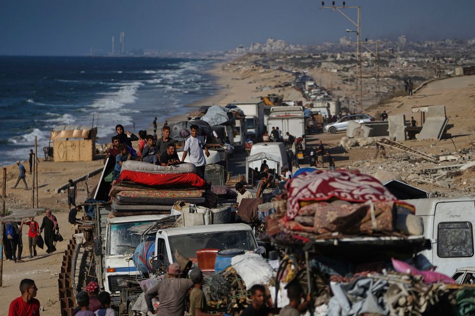 Displaced Palestinians flee northern Gaza carry their belongings along the coastal road toward southern Gaza. Photo: AP