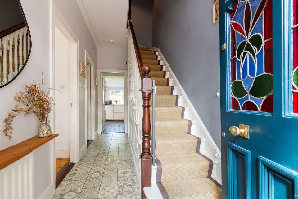 The front door, which has been painted blue, is notable for its original multi-coloured stain glass window