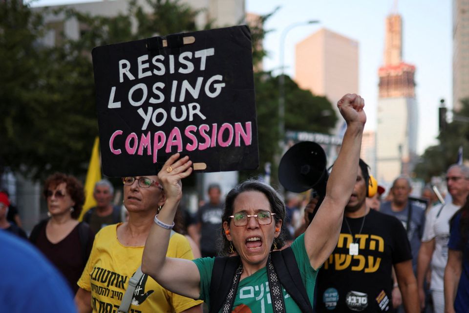 A demonstrator in Tel Aviv holds a sign during a protest demanding an end to the war in Gaza and the release of all hostages. Photo: Reuters