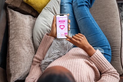 A young woman looks at a menstruation app.