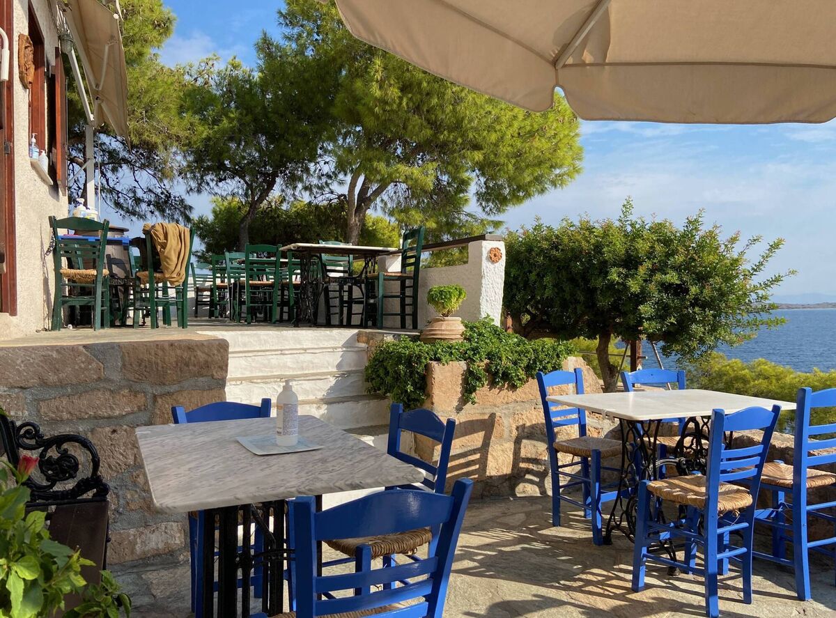 A restaurant's summer terrace on the Greek island of Agistri with views of the Aegean Sea