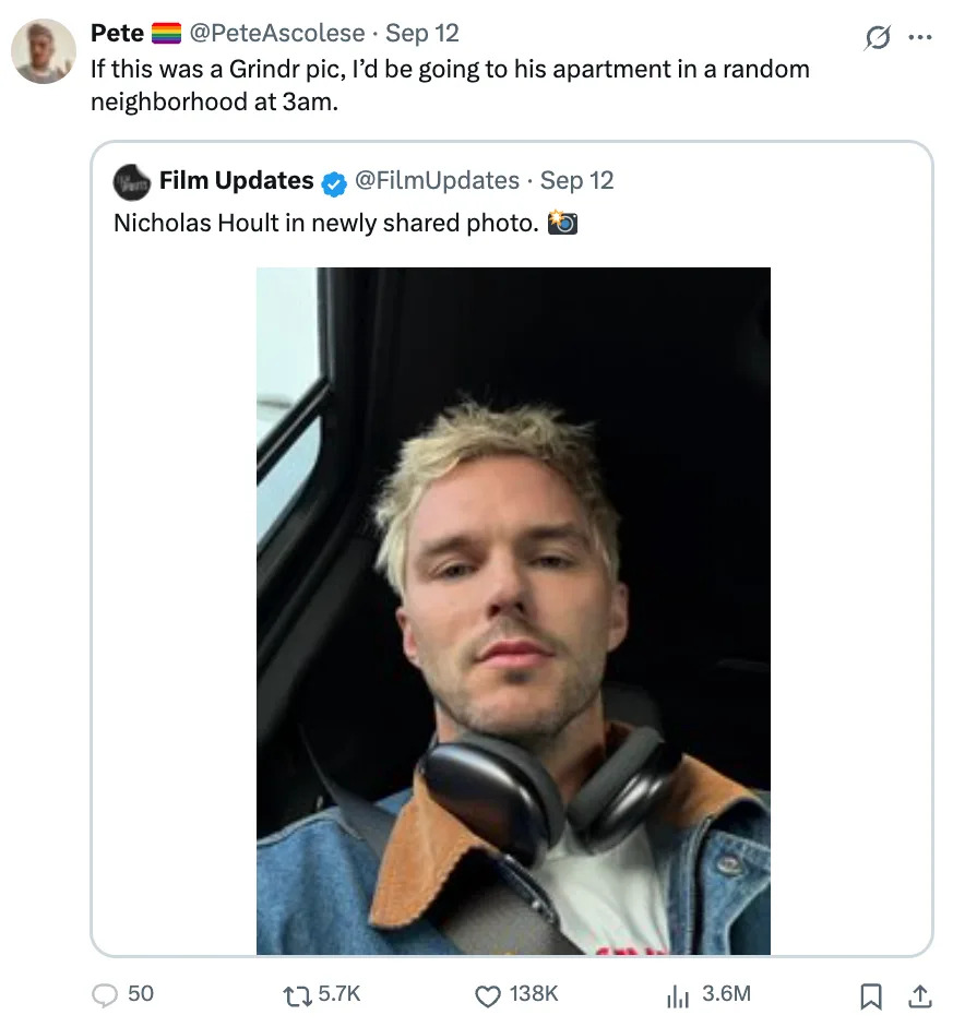 Nicholas Hoult takes a selfie in a car wearing a denim jacket with headphones around their neck