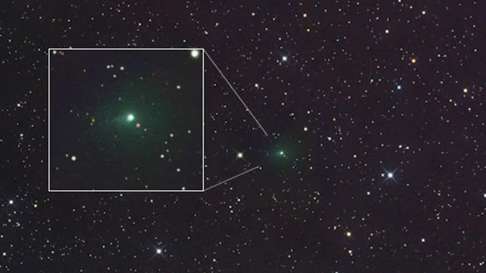  A space photo of a green comet surrounded by stars with a boxout highlighting the comet closer. 
