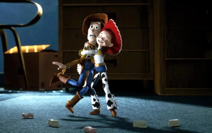 Woody and Jessie from "Toy Story" joyfully dancing in a room with scattered blocks