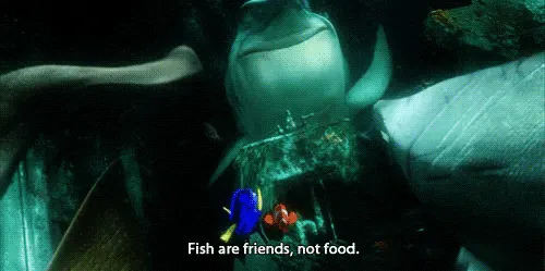 Animated scene from a movie with a shark saying, "Fish are friends, not food," to two smaller fish, Dory and Nemo