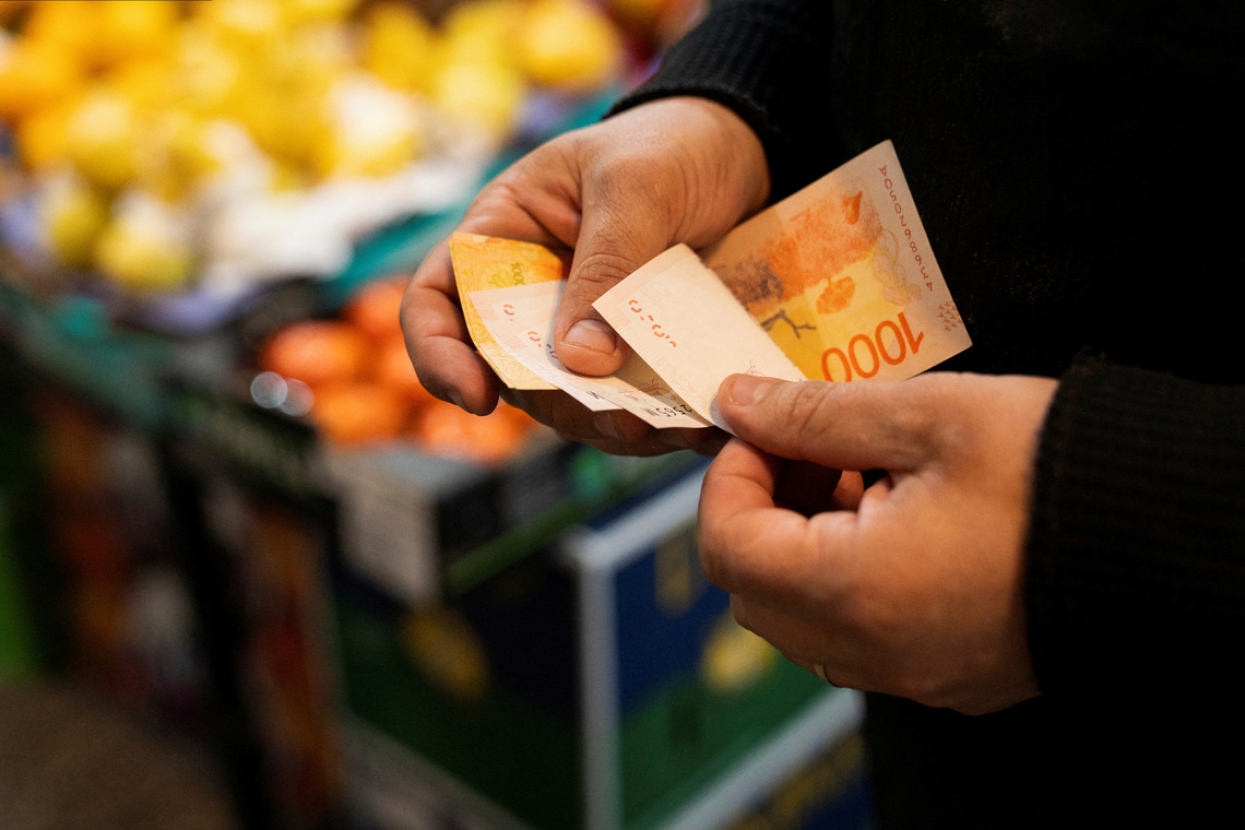 A greengrocer counts Argentine peso bills at a local market,as Argentina is due to release consumer inflation data for April, in Buenos Aires, Argentina May 11, 2024. REUTERS/Irina Dambrauskas/File Photo