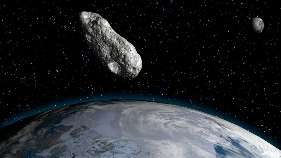  An artist's illustration of an asteroid flying past Earth and the moon. 