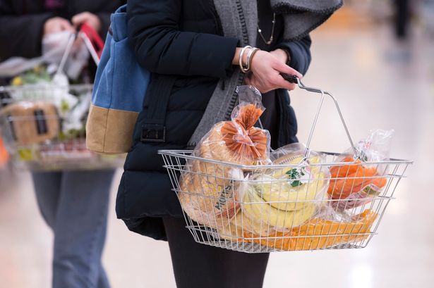 Undated file photo of a woman shopping holding a basket.