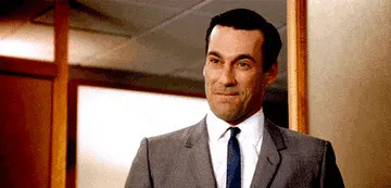 Man in a suit confidently smiles while in an office setting
