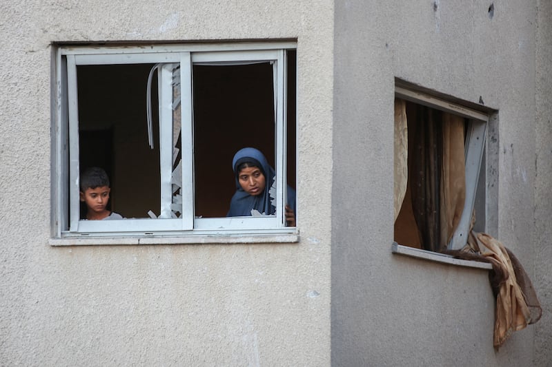 Palestinians look at the rubble of a neighbouring building hit by an Israeli strike in the Nuseirat refugee camp. Photograph: Eyad Baba/AFP/Getty Images       