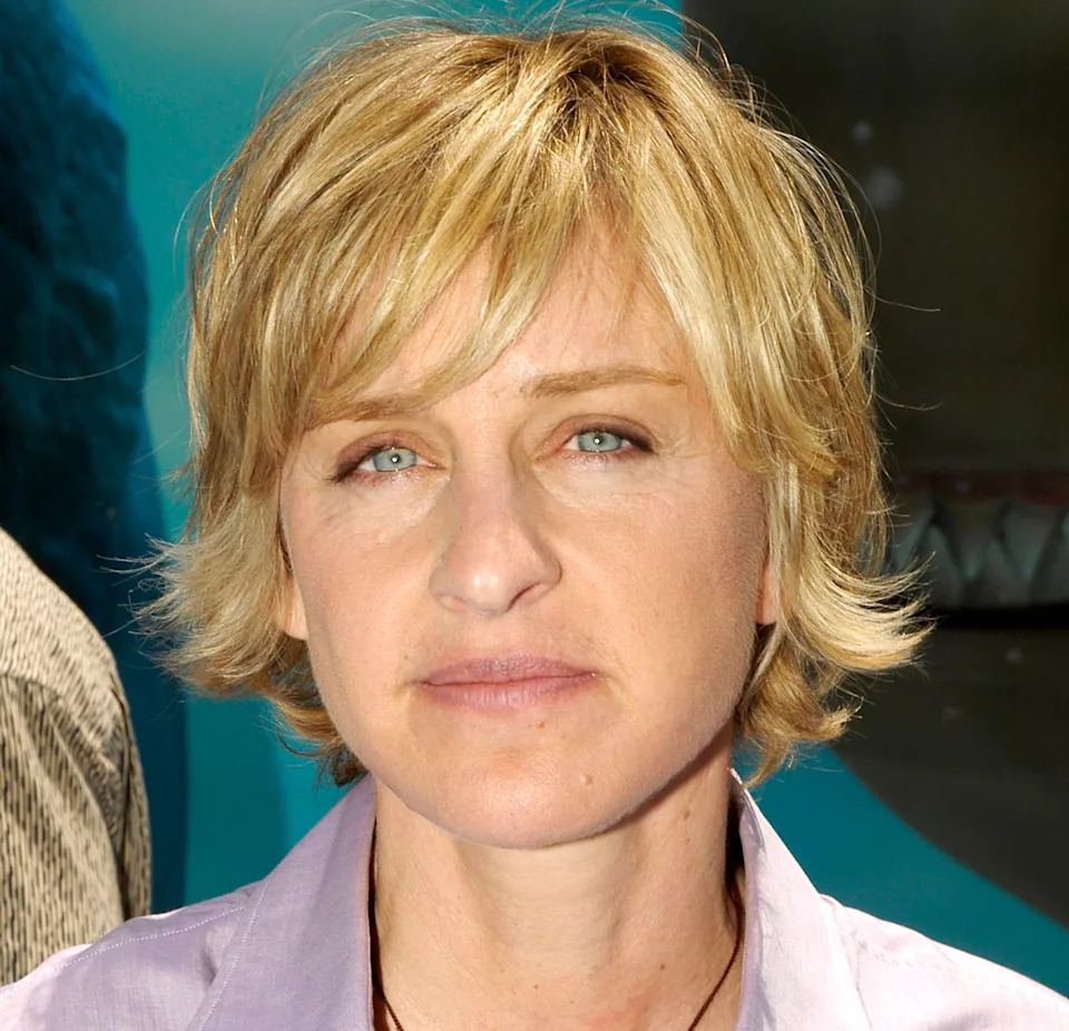 Person with short, layered hair in a collared shirt, attending an event