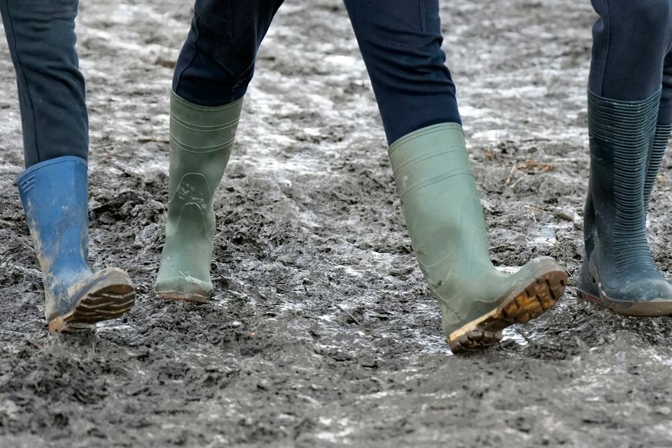 People walking in muddy conditions during the National Ploughing Championships at Tullamore, Co Offaly. Photo: Niall Carson/PA Wire