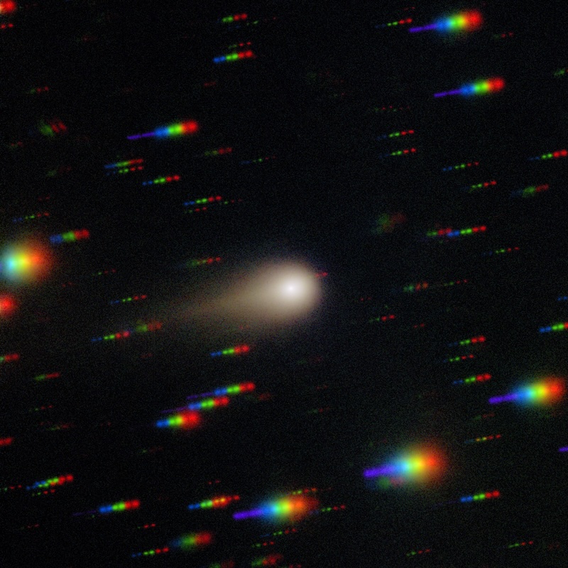 3I/ATLAS. Streaked spectrum of stars in the background with a glowing ball in the center with a tail showing a comet.