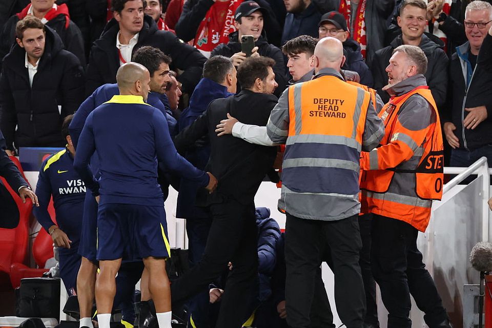 Diego Simeone, manager of Atletico Madrid is restrained as he confronts fans after the late Liverpool winning goal during the UEFA Champions League match against Liverpool at Anfield. (Photo by Marc Atkins/Getty Images)
