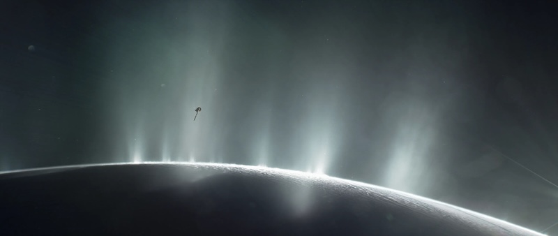 Shadowed edge of planet-like body with several bright plumes erupting from the surface. Small spacecraft close to the plumes.