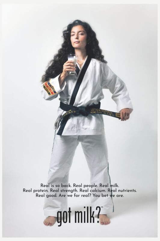 A woman in a martial arts uniform with a black belt stands confidently holding a glass of milk. Text at the bottom says “got milk?” and describes the benefits of real milk, including strength and nutrients.