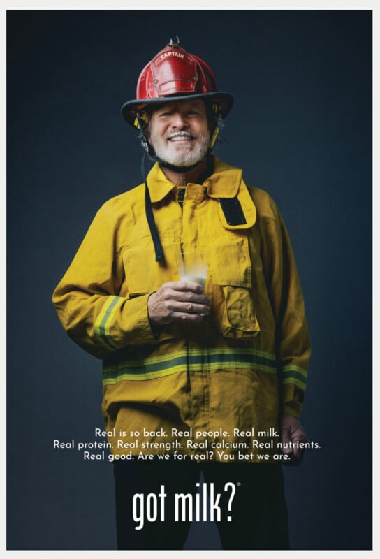 A smiling firefighter wearing a red helmet and yellow jacket holds a glass of milk. The text at the bottom reads, "got milk?" with a message about the benefits of milk above it.