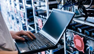 IT specialist working on computer in bitcoin and crypto currency mining farm.