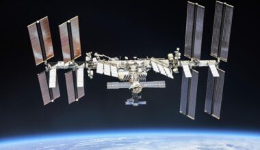 International Space Station with large solar panels on either end floating above Earth.