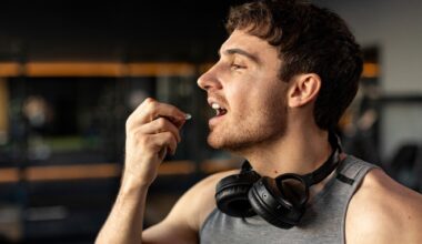Sportive man taking supplement capsule,
