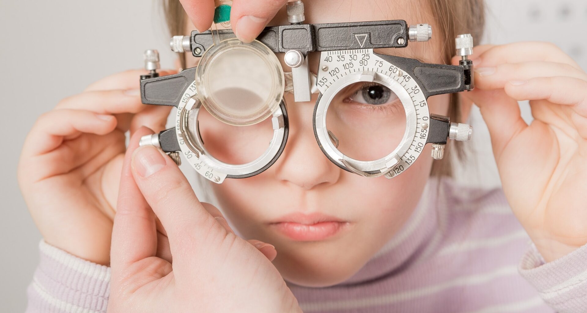 young girl smiling while undergoing eye test