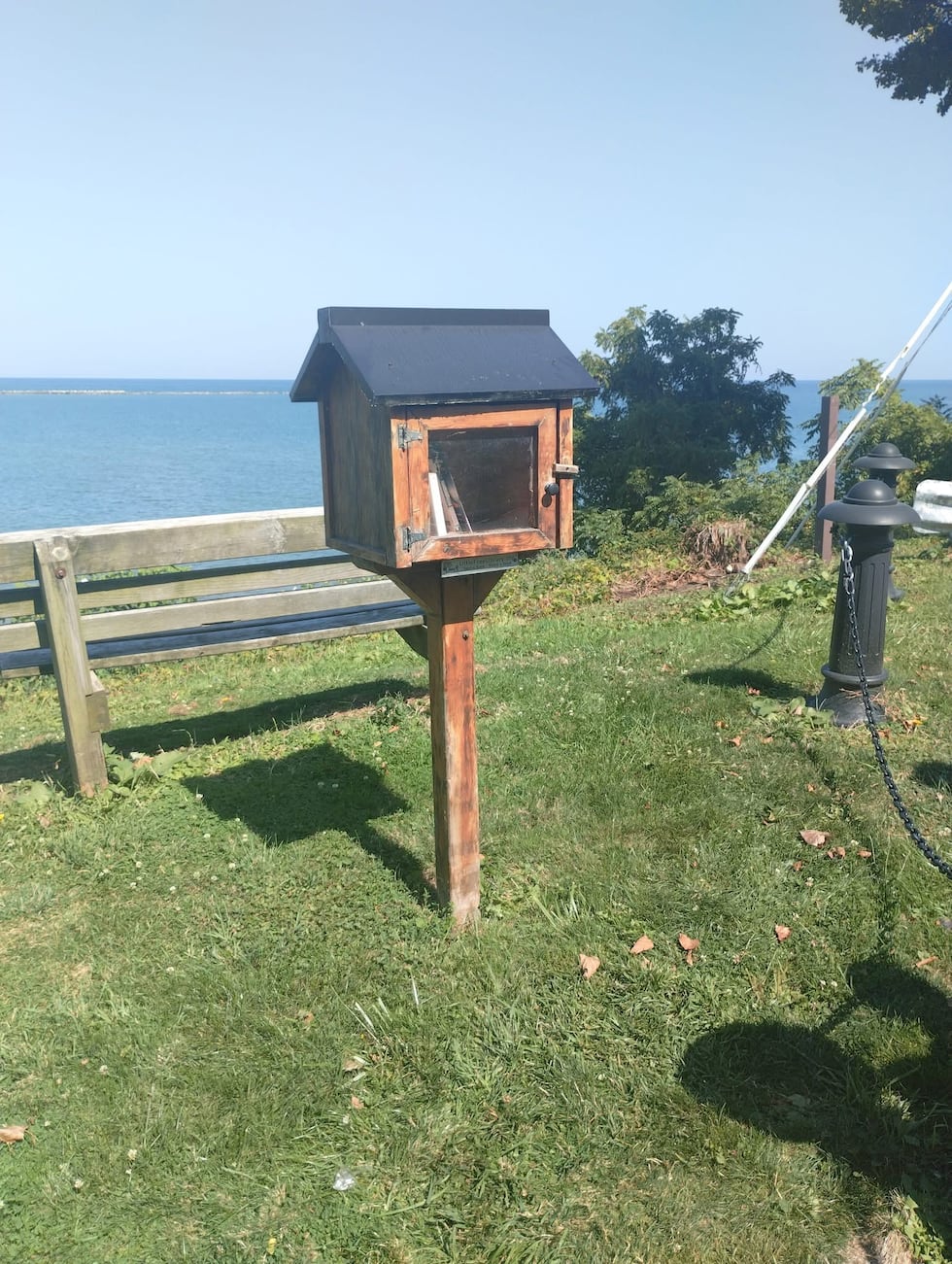Fairport Harbor free little library books torn apart, scattered down beach path