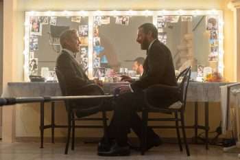 George Clooney as Jay Kelly and Adam Sandler as Ron Sukenick share a scene on the set of Jay Kelly, directed by Noah Baumbach. Photo by Peter Mountain, Netflix (2025).