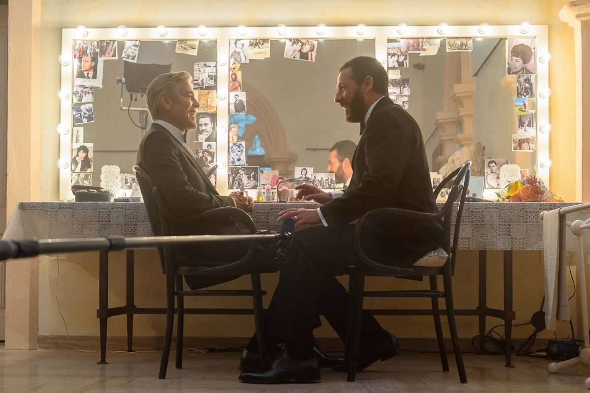 George Clooney as Jay Kelly and Adam Sandler as Ron Sukenick share a scene on the set of Jay Kelly, directed by Noah Baumbach. Photo by Peter Mountain, Netflix (2025).