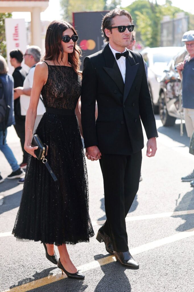 Kaia Gerber in Givenchy black lace dress Venice Film Festival with Lewis Pullman in Saint Laurent