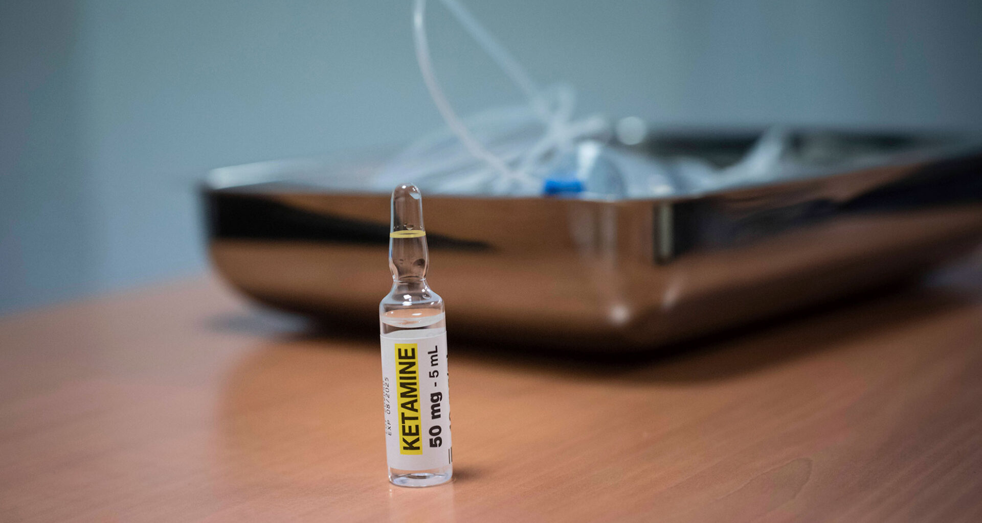 Ketamine in foreground with an IV tube in background.