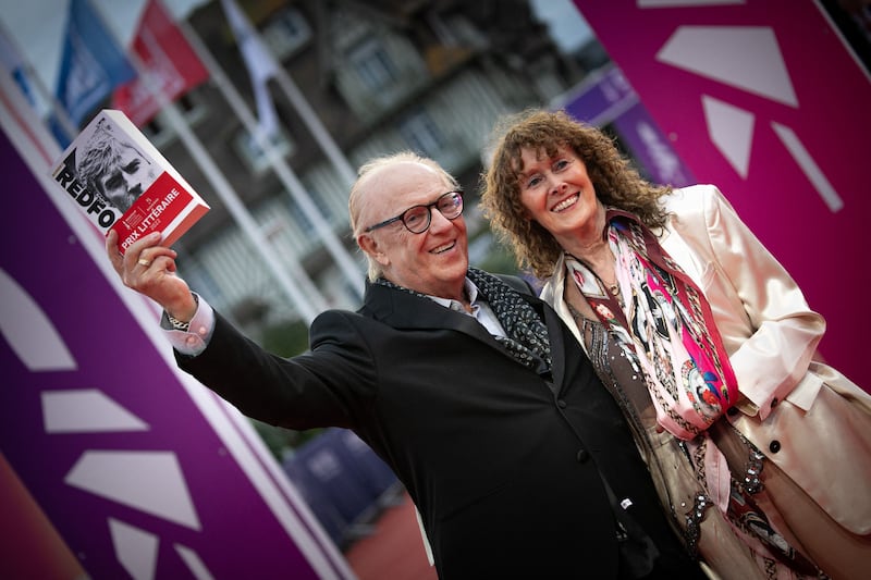 Irish writer Michael Feeney Callan holds his prize-winning book Robert Redford as he poses with Tiffany Gassouk on the red carpet of the 48th Deauville American Film Festival in Normandy, 2022. Photograph: Lou Benoist/ AFP via Getty Images