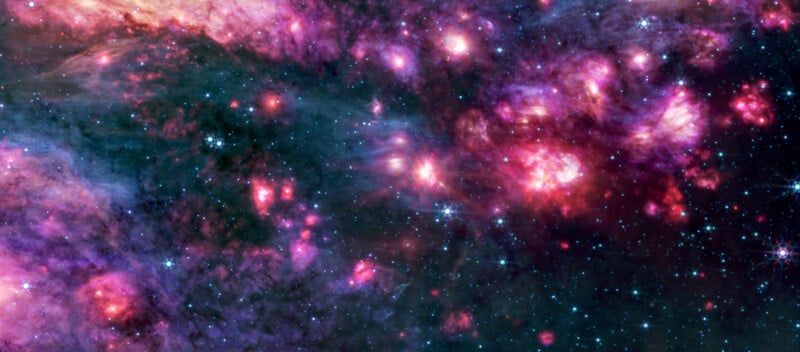 A colorful cosmic scene showing bright pink, purple, and blue nebula clouds scattered with sparkling stars in deep space. The image glows with vibrant regions of light and shadow.