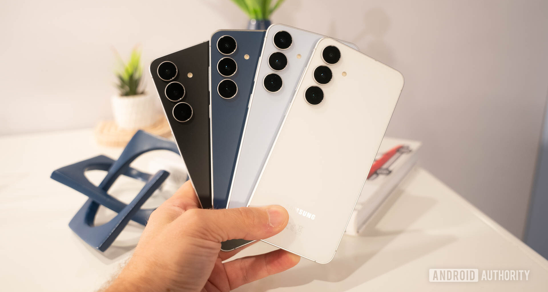 Samsung Galaxy S25 FE in all four colors fanned out in man's hand