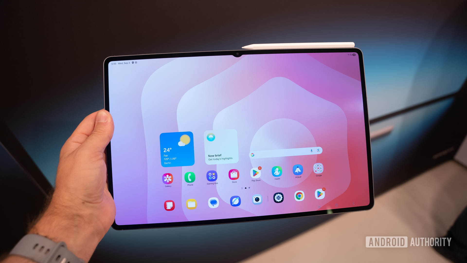 Samsung Galaxy Tab S11 Ultra in man's hand showing home screen